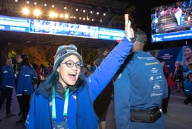 A NYRR staffer high-fiving runners at the finish line of a race. 