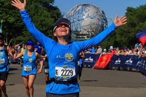 Runner crossing the finish line at the Queens 10K