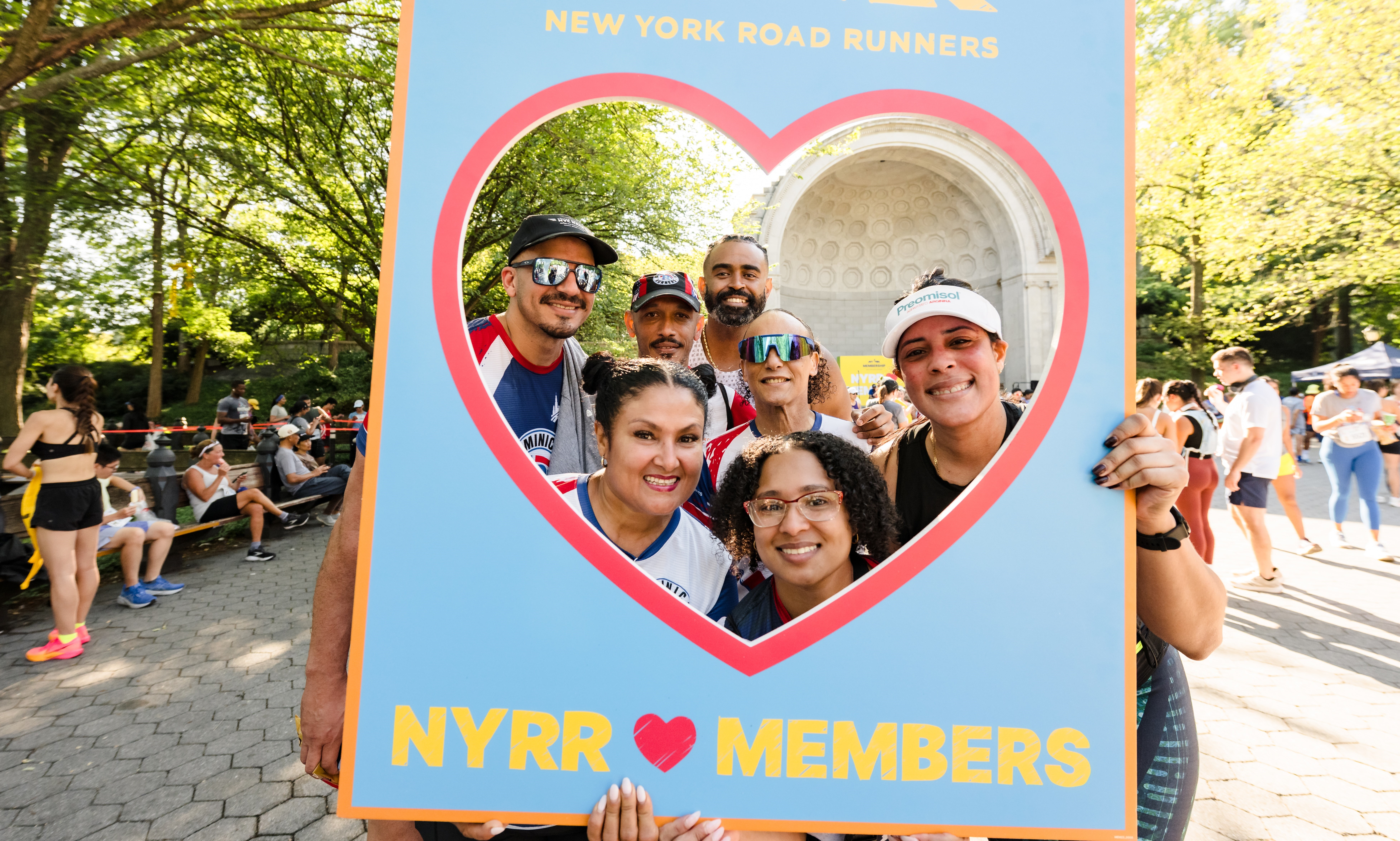 Members with a cut out sign with a heart shape and text that says NYRR loves members