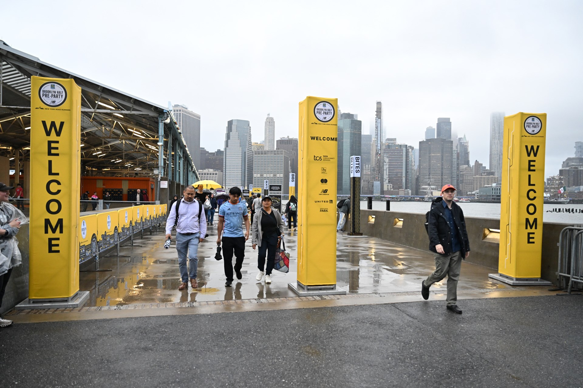 A rainy shot of people leaving the 2025 RBC Brooklyn Half Pre-Party at Pier 2 in Brooklyn