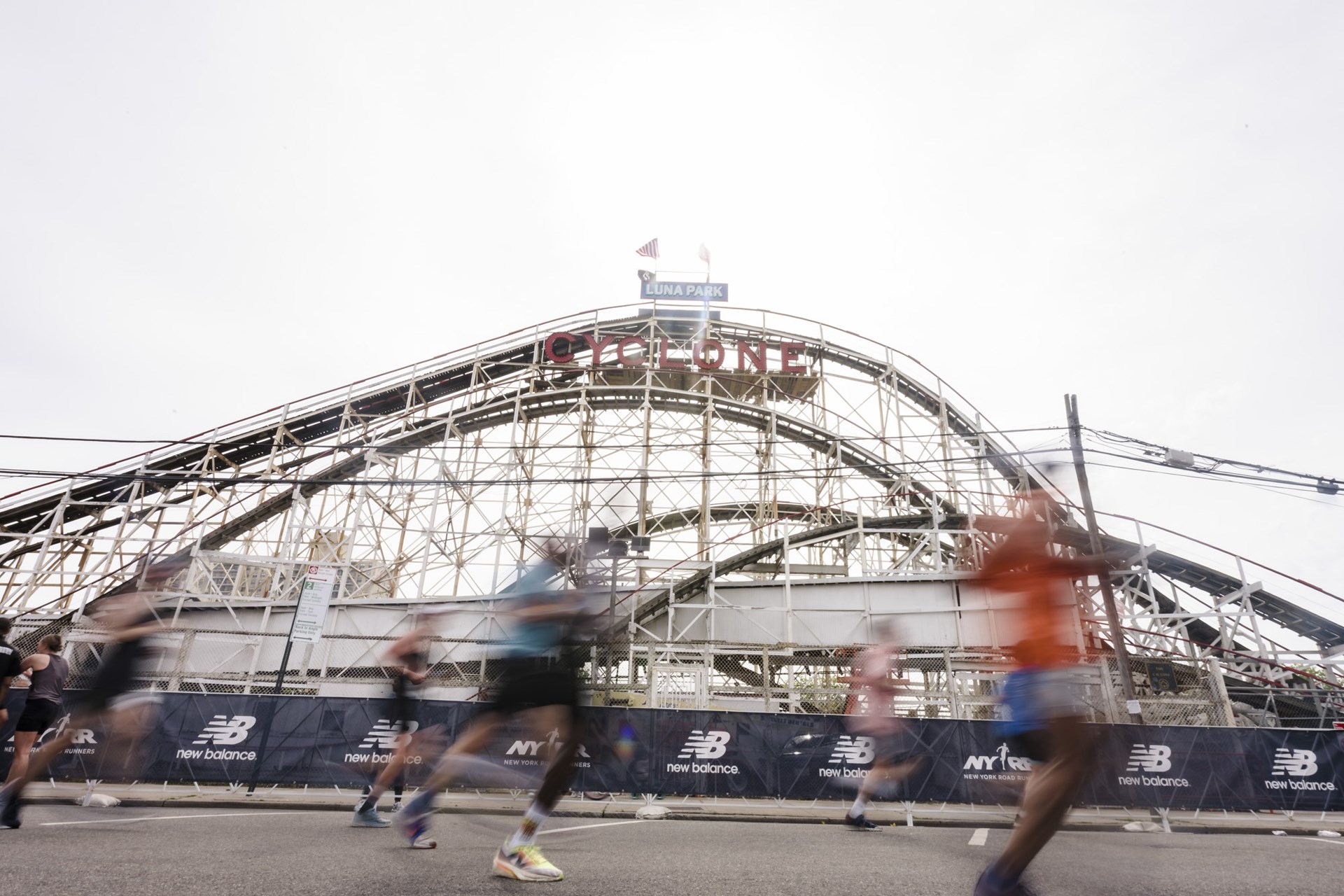 A blurry image of runners running past the Cyclone roller coaster in Coney Island for the RBC Brooklyn Half