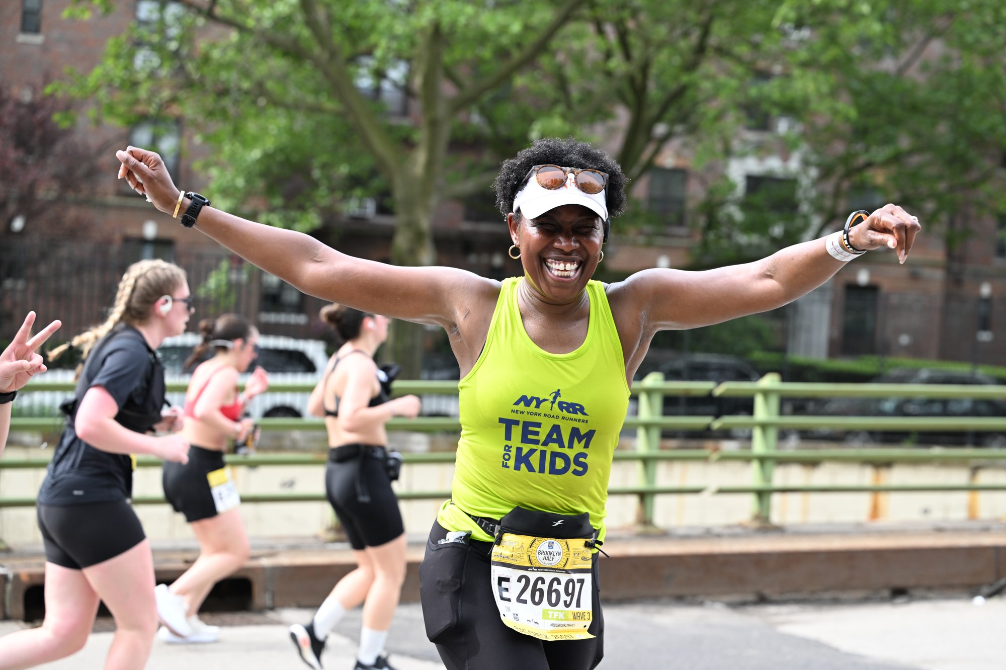 Team for Kids runner with arms outstretched at the RBC Brooklyn Half