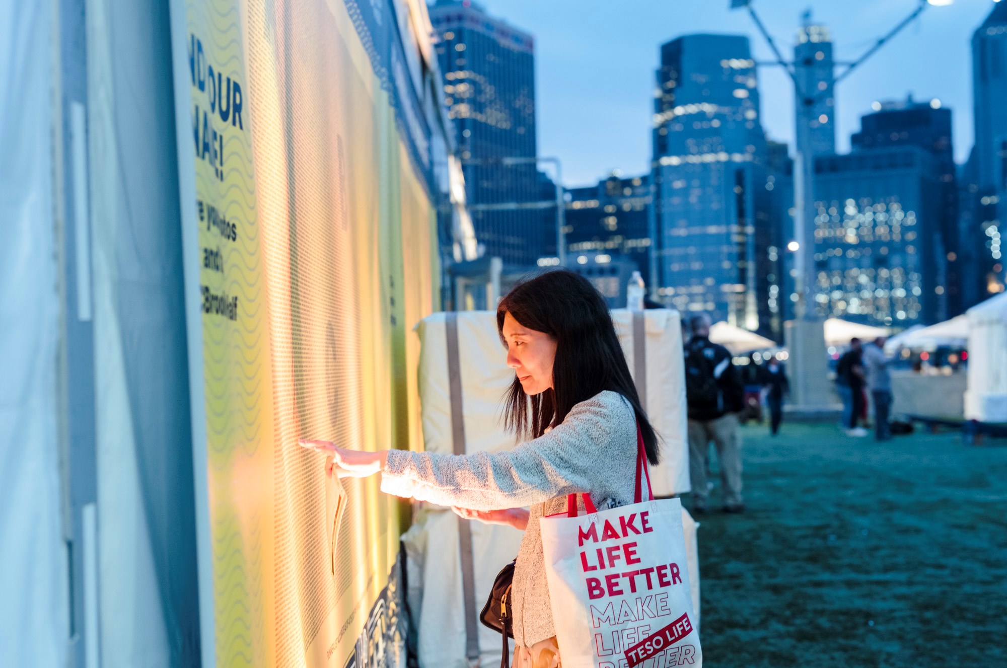 A woman searches for her name on the name wall at the 2025 RBC Brooklyn Half Pre-Party