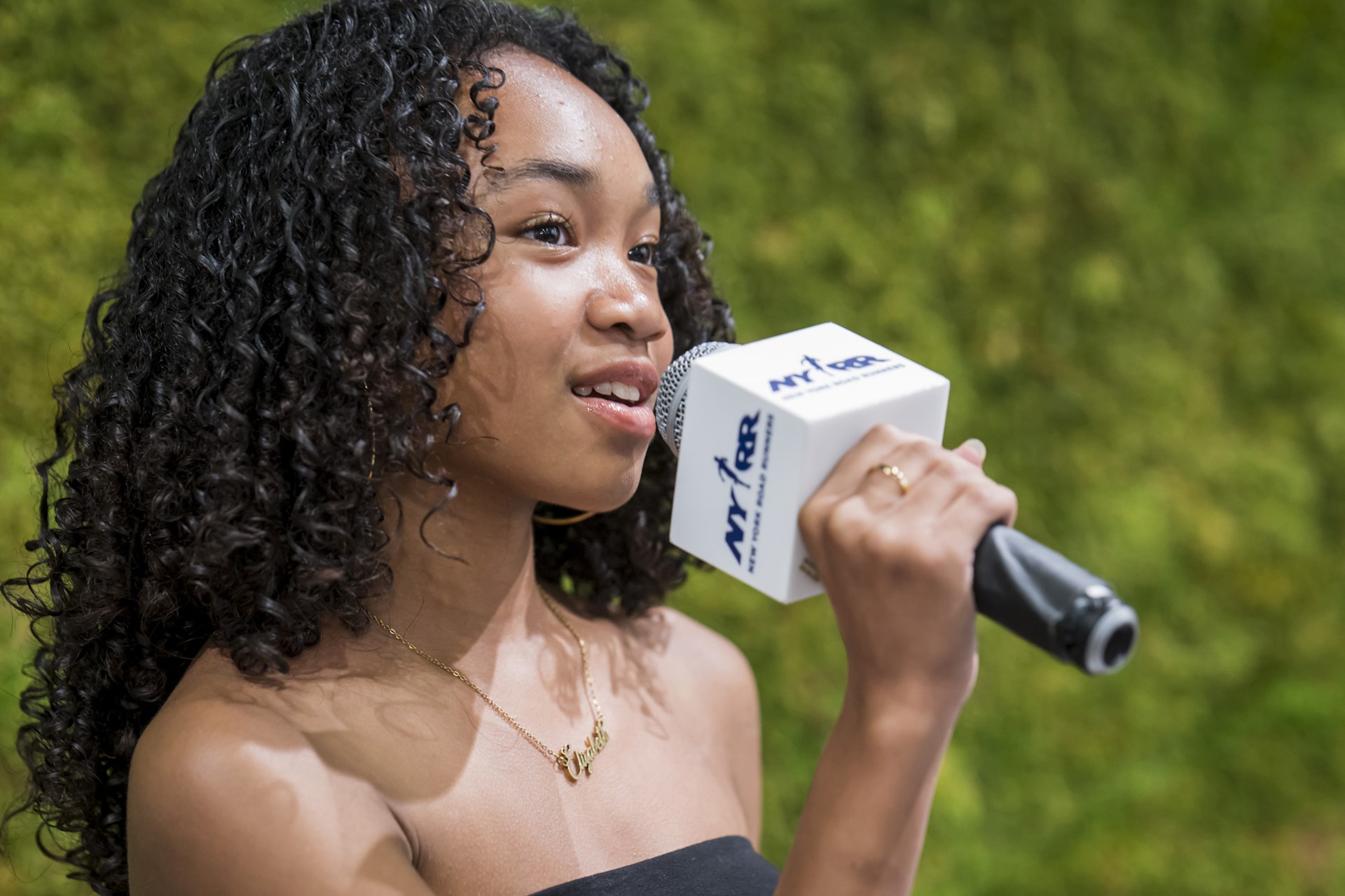 A youth ambassador speaks into a mic