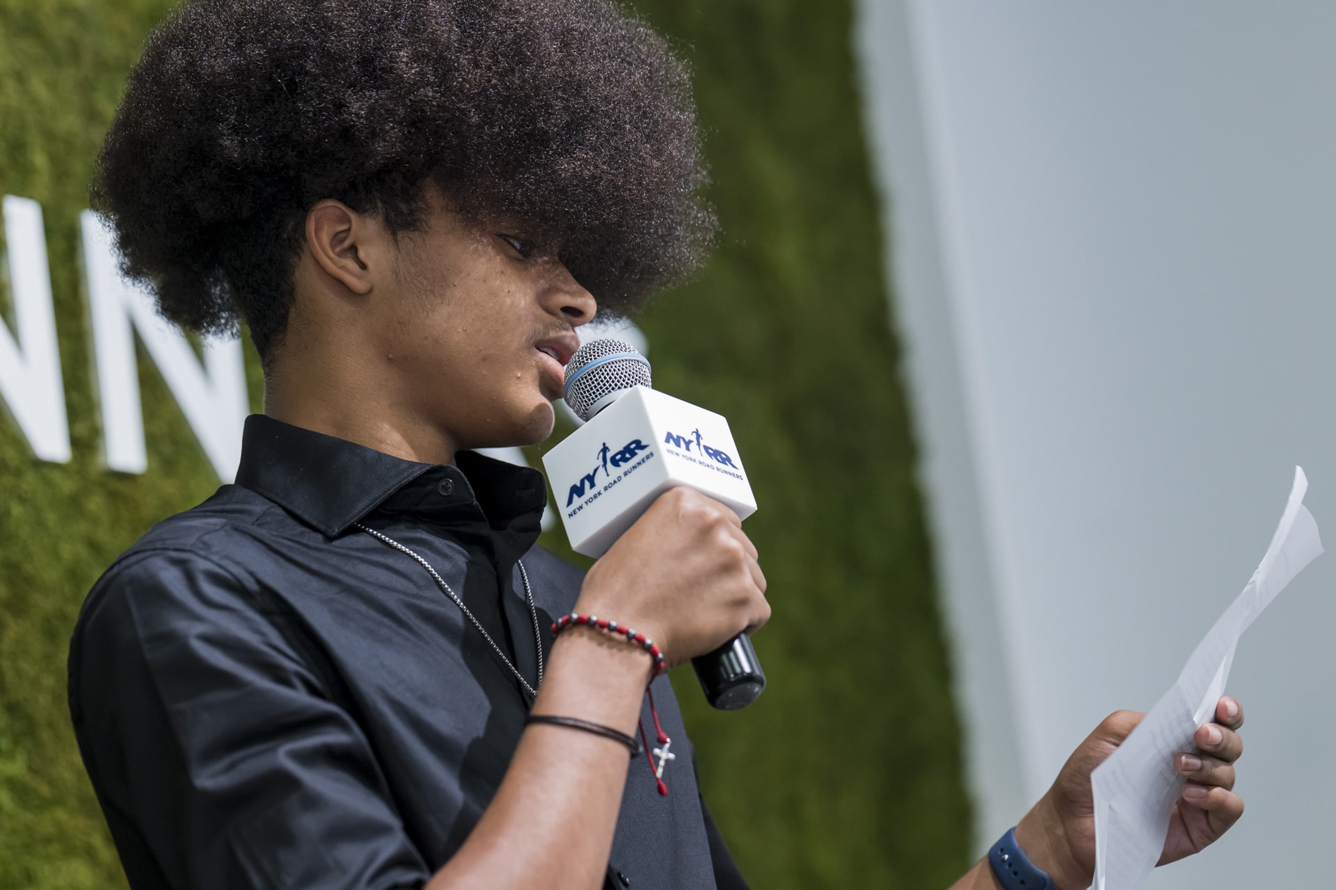 A youth ambassador speaks into a mic at graduation