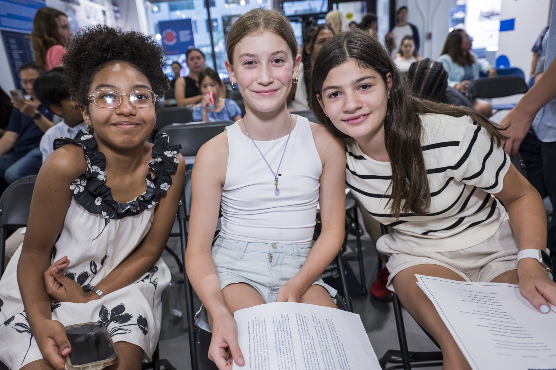 Three female youth ambassadors smile for a picture at graduation
