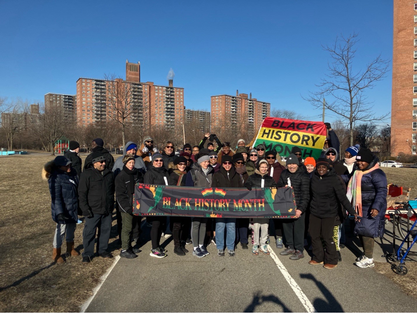 Group photo of runners with Black History Month banner and flag