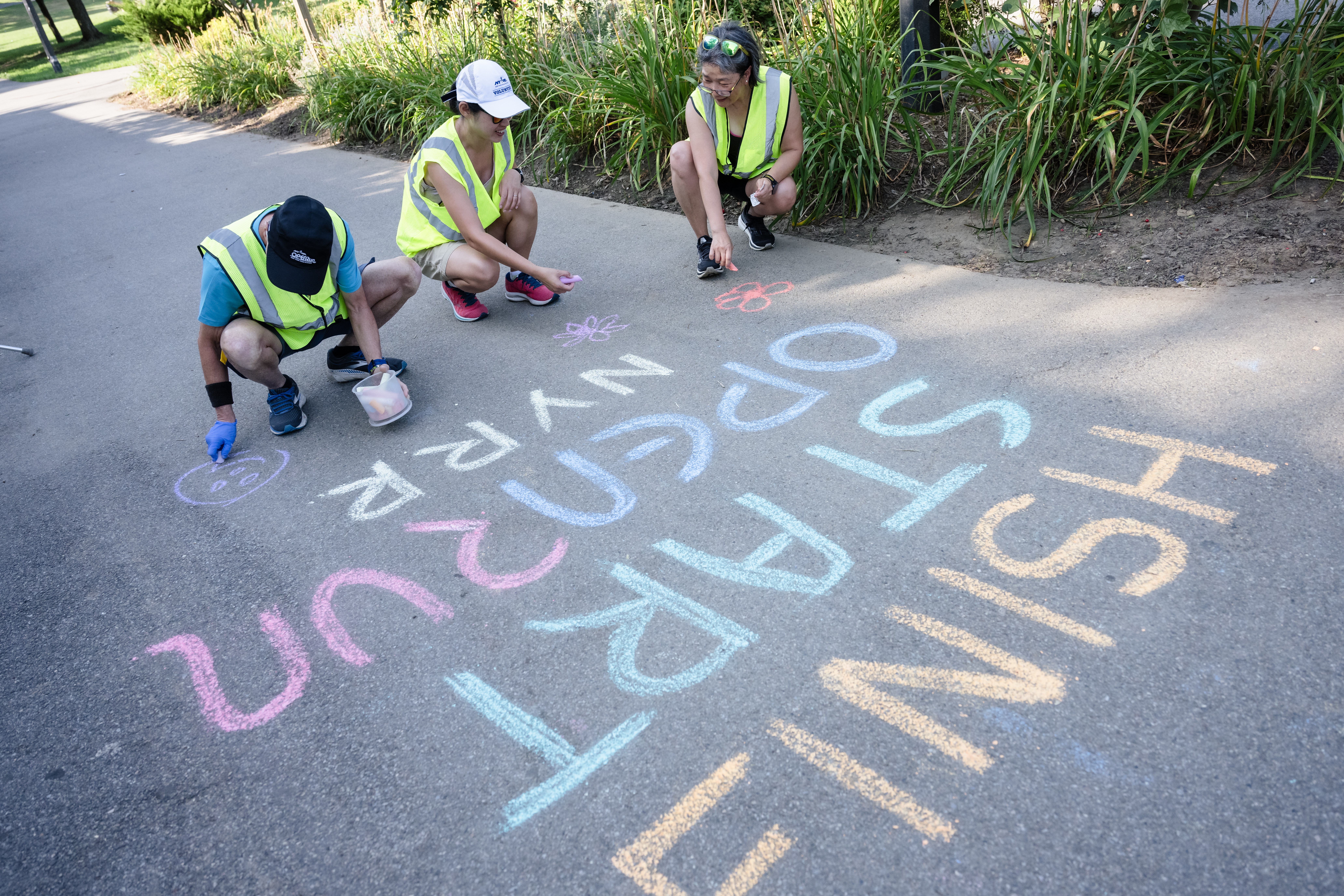 Open Run Volunteers writing on sidewalk with chalk