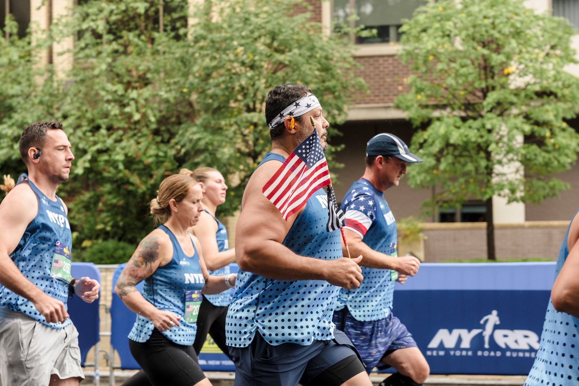 NYPD runner holding a flag on the New Balance 5th Avenue Mile course
