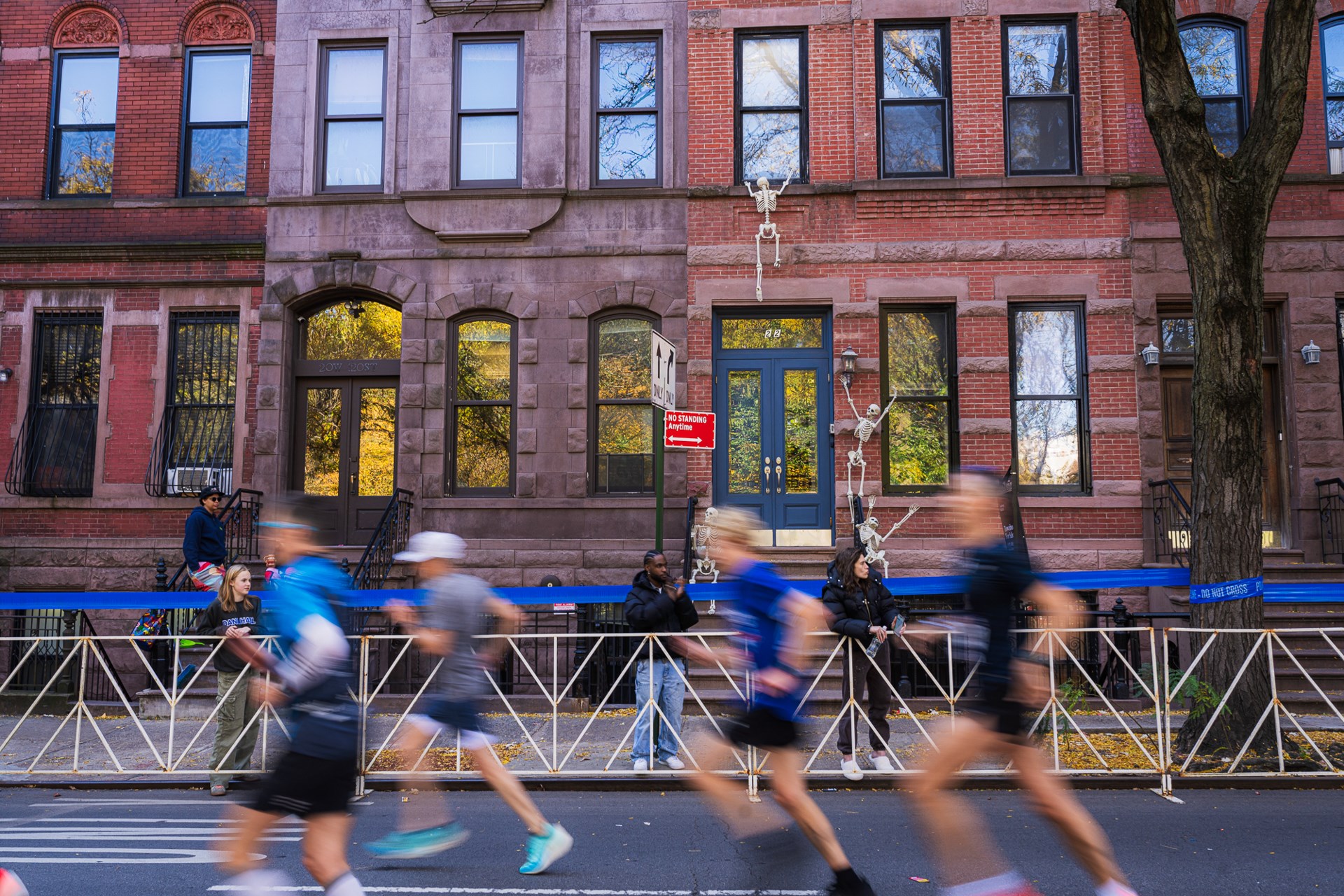 Blurred runners passing brownstones in 2025 TCS NYC Marathon