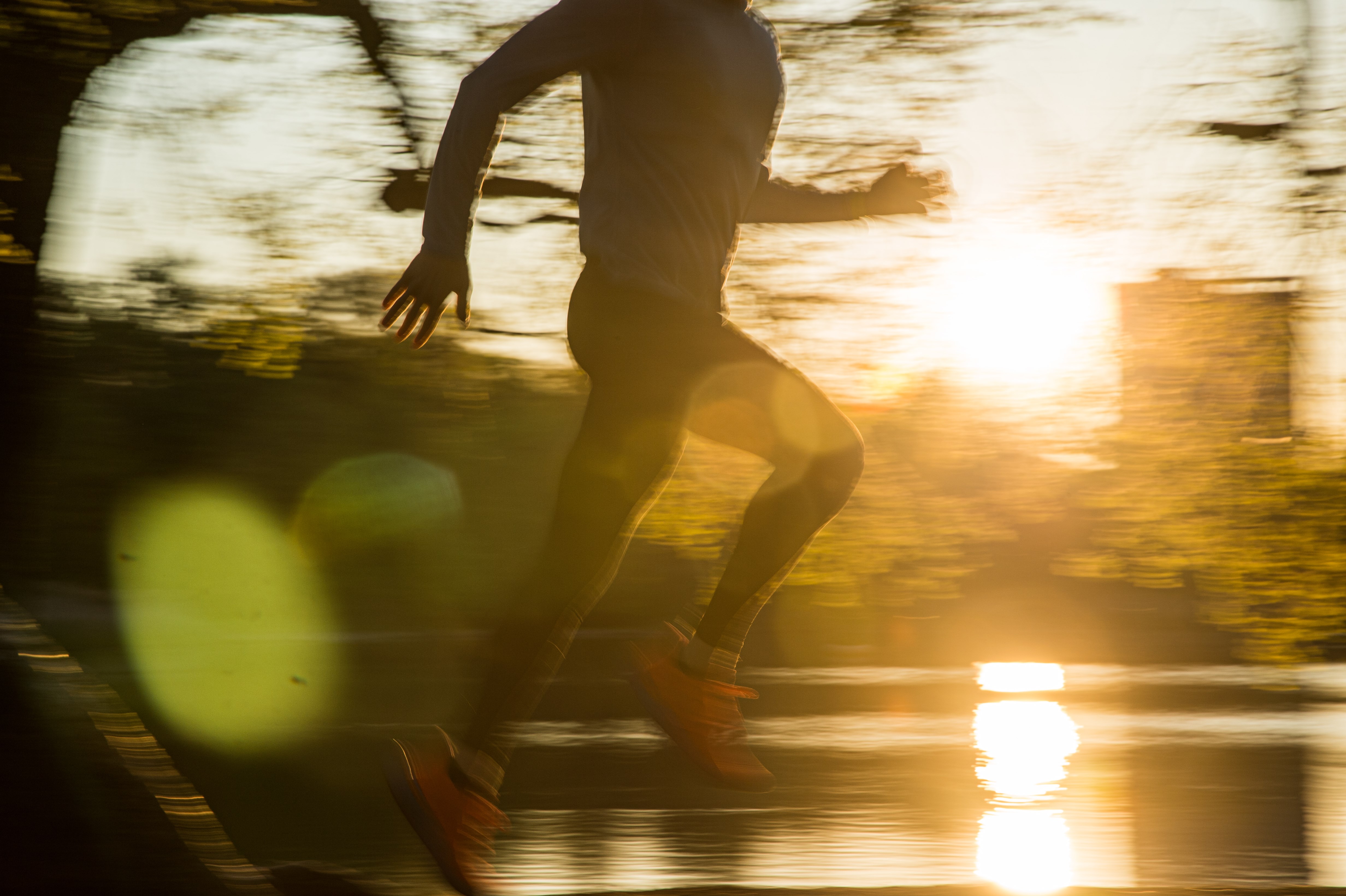 Runner silhouette with sunset and water backdrop