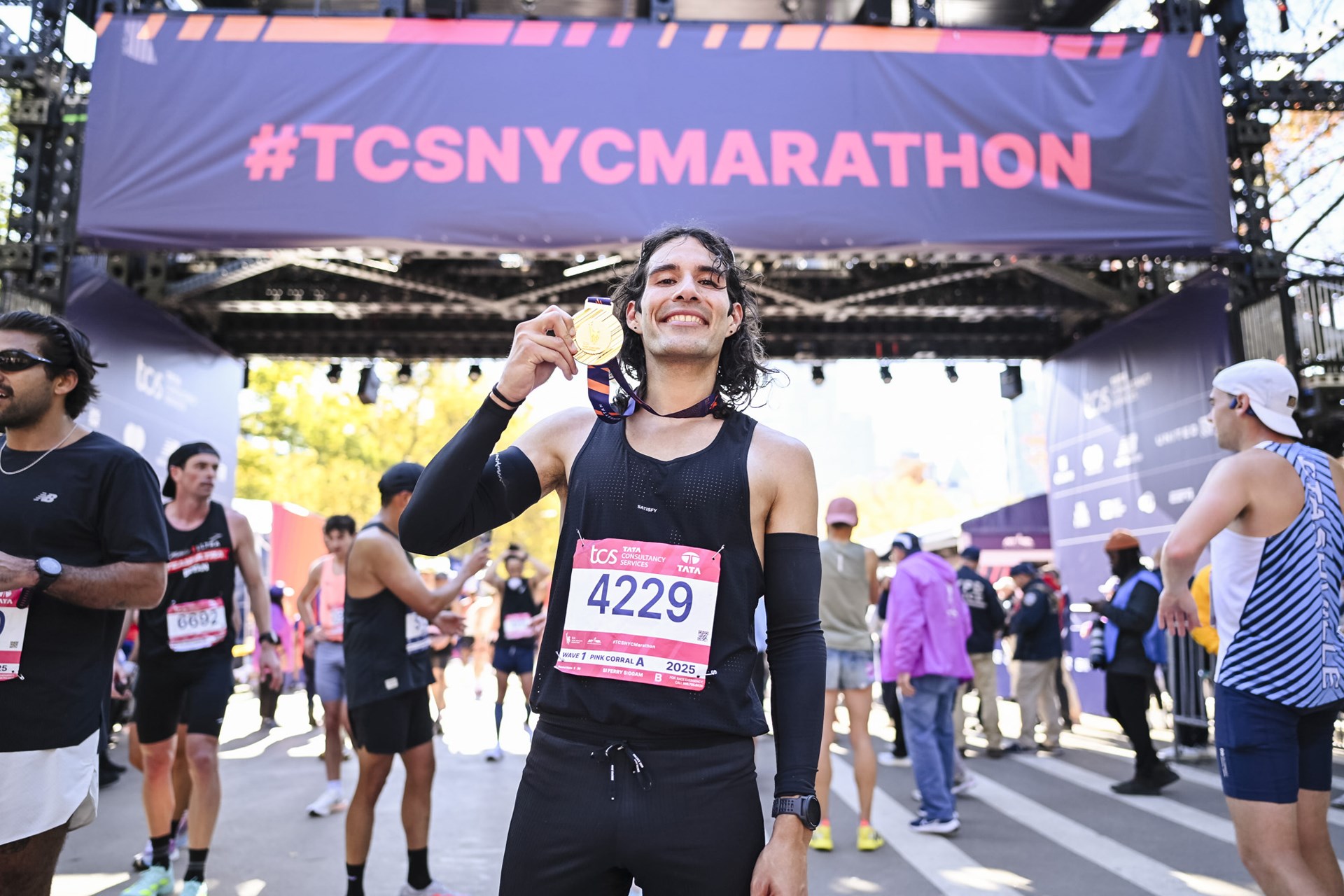 Top nonbinary runner Daniel Mata holding medal after finishing 2025 TCS NYC Marathon