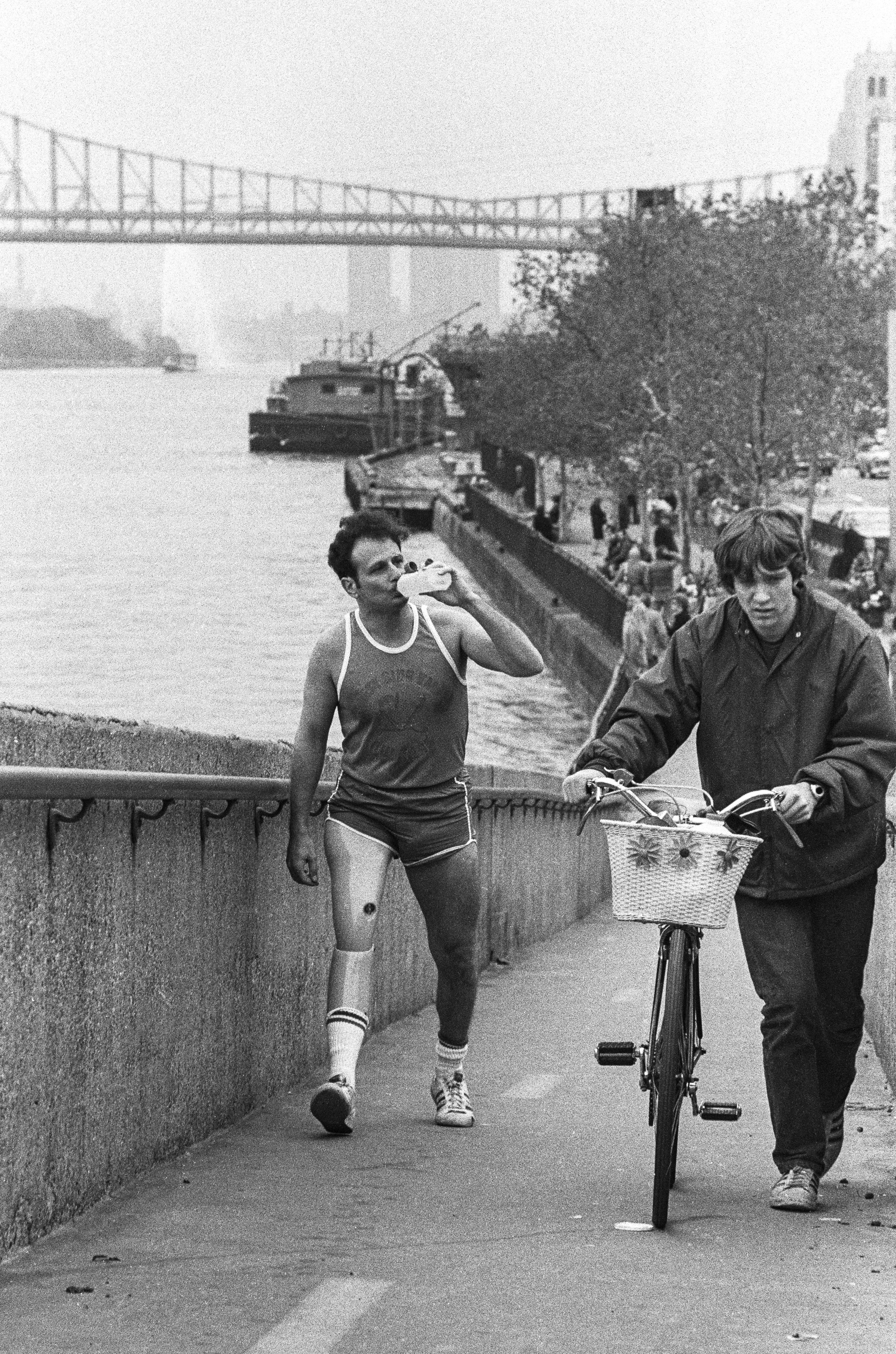Dick Traum with prosthesis running 1976 New York City Marathon along East River up ramp.