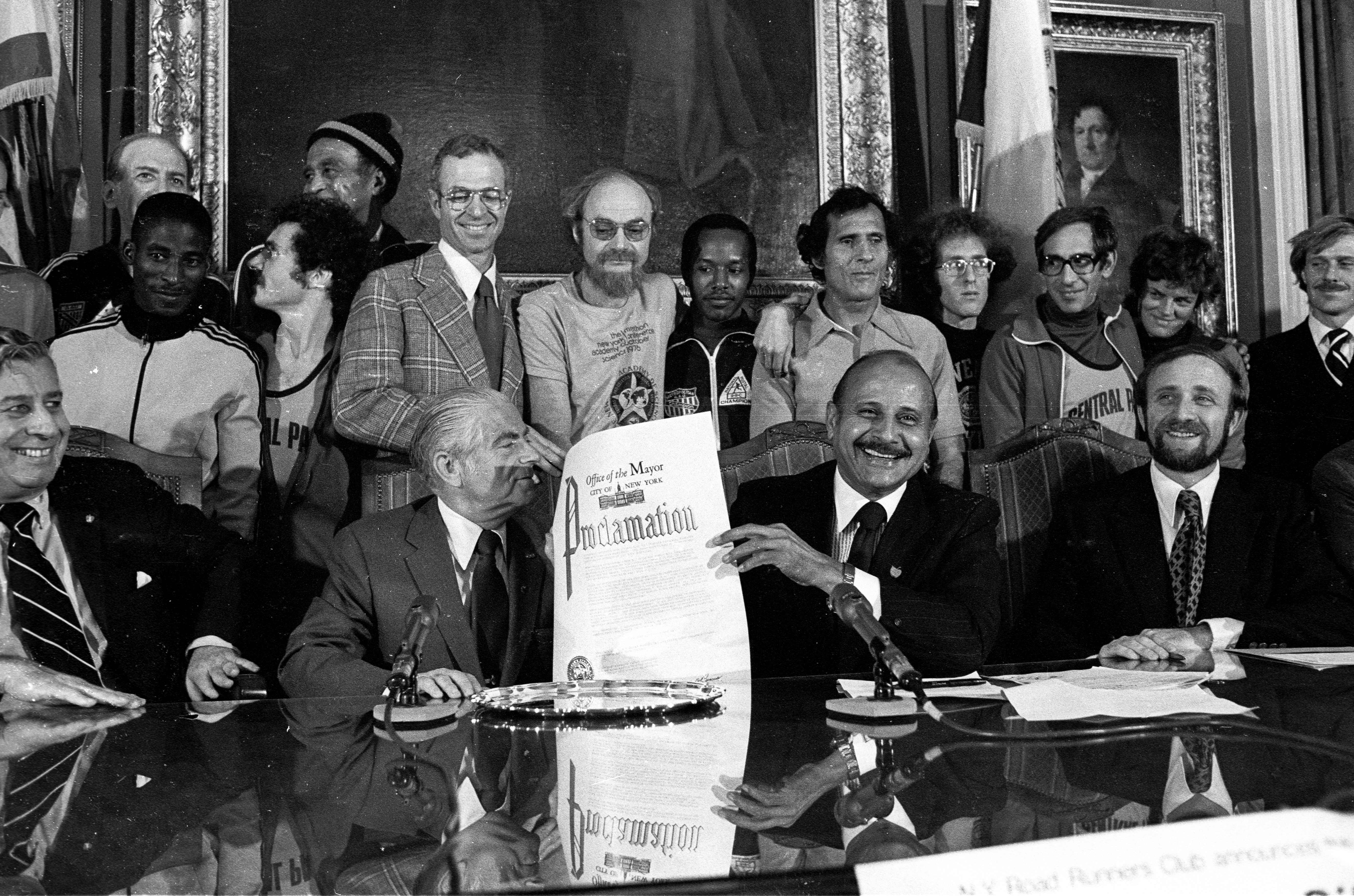 Black and white photo of the proclamation of the first five borough New York City Marathon in 1976 in the Mayor's office of NYC.