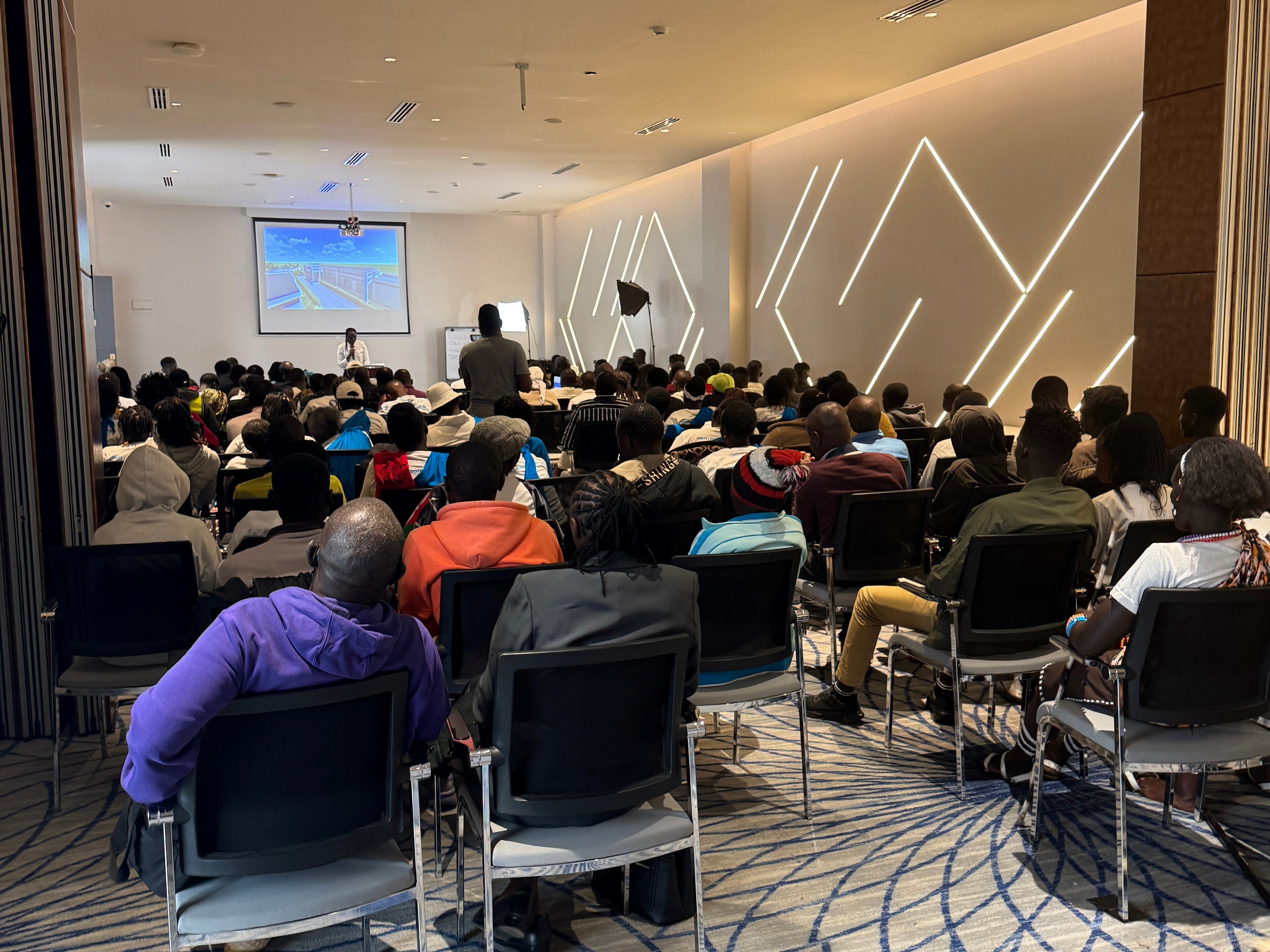 A member of the Tirop's Angels staff giving an overview of the organization's programming to attendees of the stakeholder meeting, Kenya, February 2026.