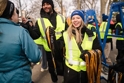 Volunteer handing runner their medal at the NYRR Manhattan 10K. 