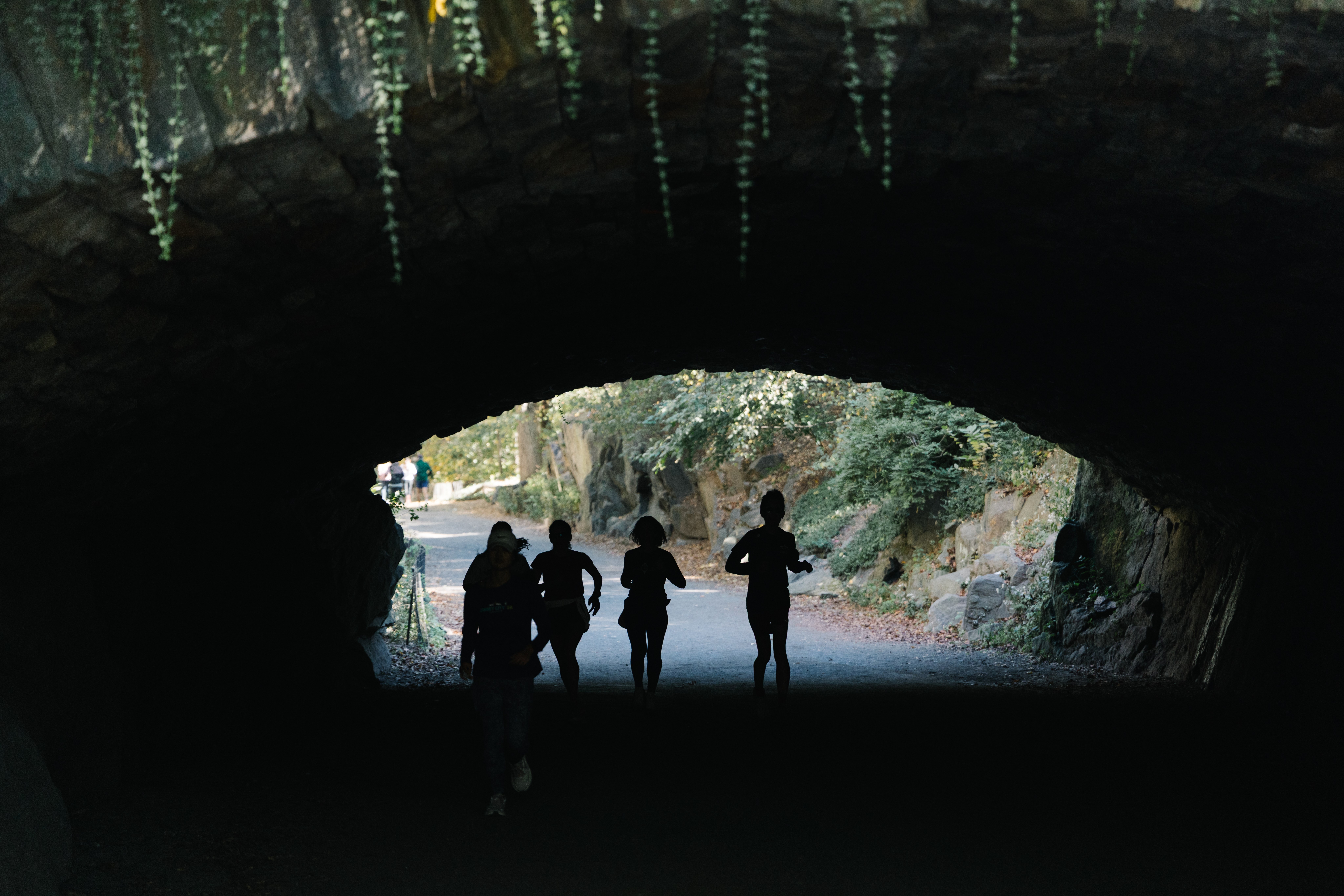 Women runners under a bridge in half light in Central Park in 2025