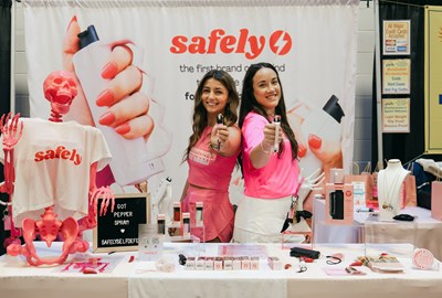 Ashley Raymond and Meagan Doyle at a Safely booth indoors with products and props.
