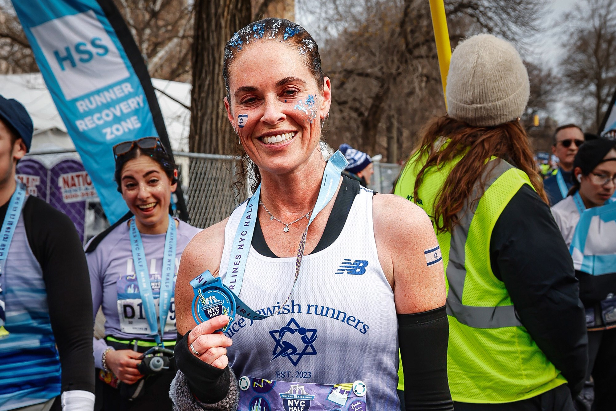 Tehila Novak with Nice Jewish Runners singlet holding medal after 2026 UA NYC Half in Central Park NYC