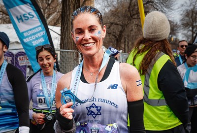 Tehila Novak with Nice Jewish Runners singlet holding medal after 2026 UA NYC Half in Central Park NYC
