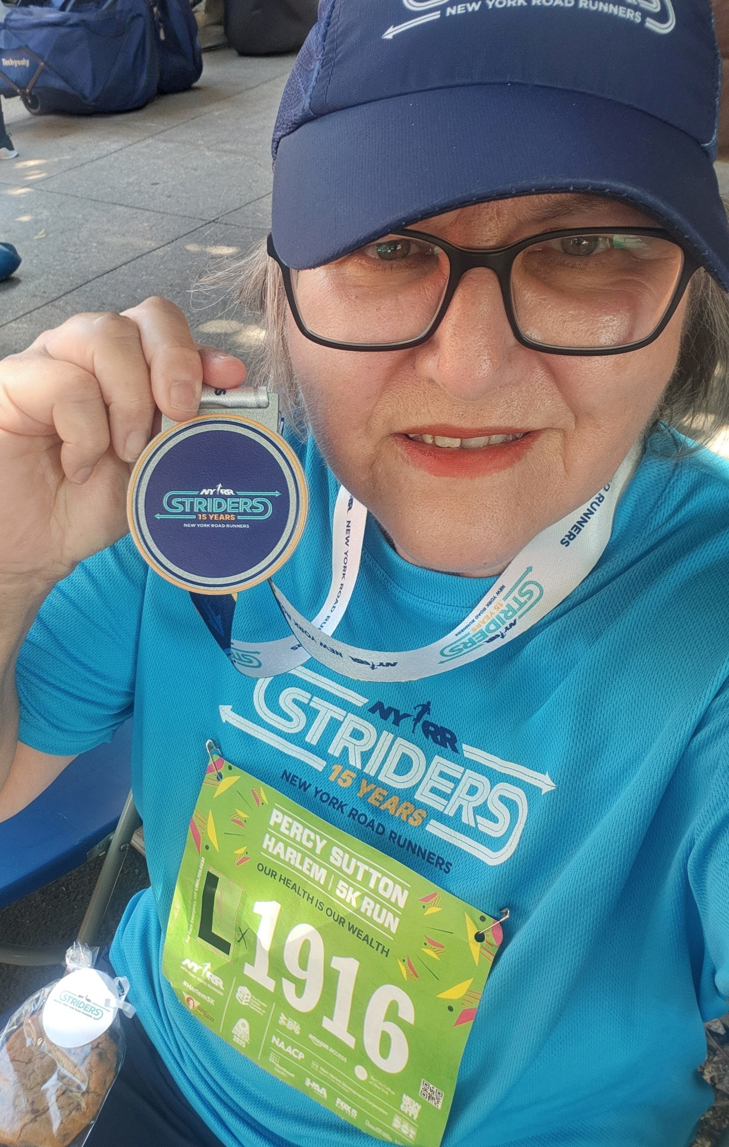 Donna Nerges with Striders medal, cap, and race bib